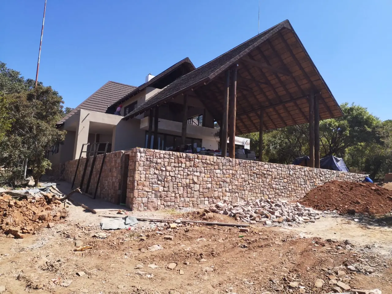 House under construction with stone wall and timber gable, Mabula