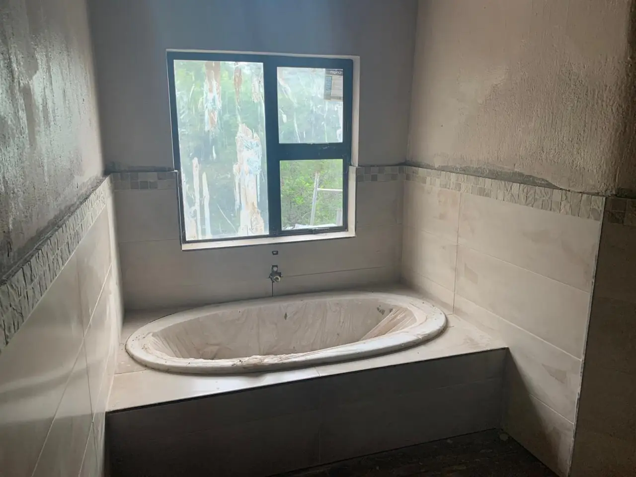 Bathroom with built-in bath and tiling in progress