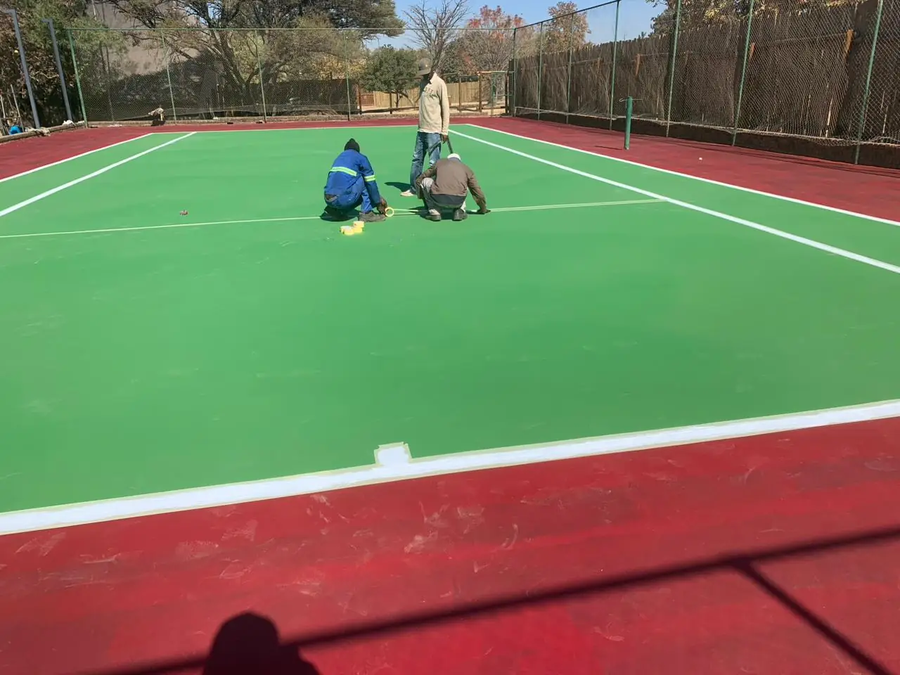 Team marking out the tennis court