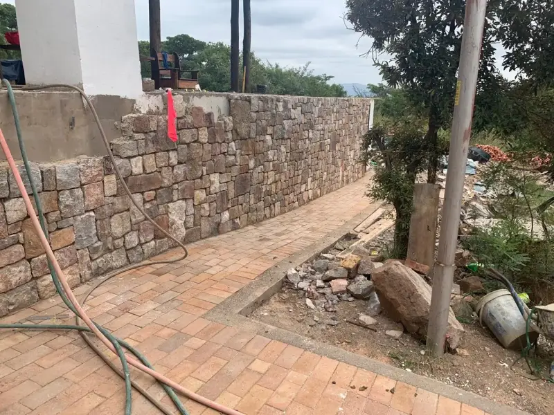 Stone retaining wall and brick paving in progress