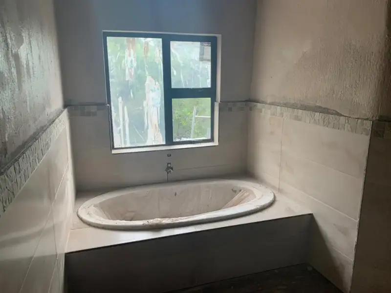 Bathroom with built-in bath and tiling in progress